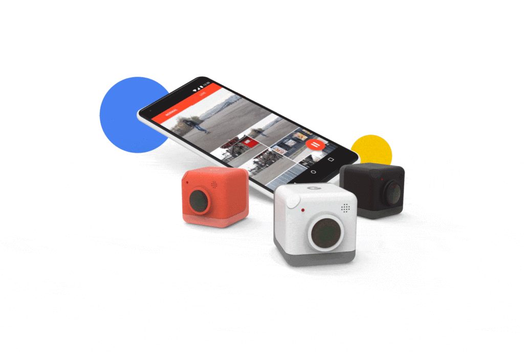 Trois petites caméras colorées posées devant un téléphone qui affiche l'application Google Capture.