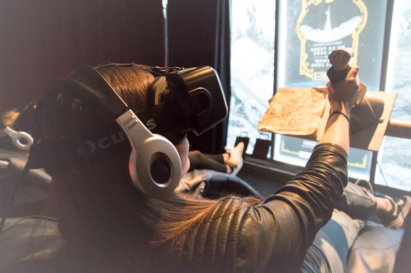 Une visiteuse équipée d'un casque de réalité virtuelle, joystick en main, dans l'installation [VR]NE#3.